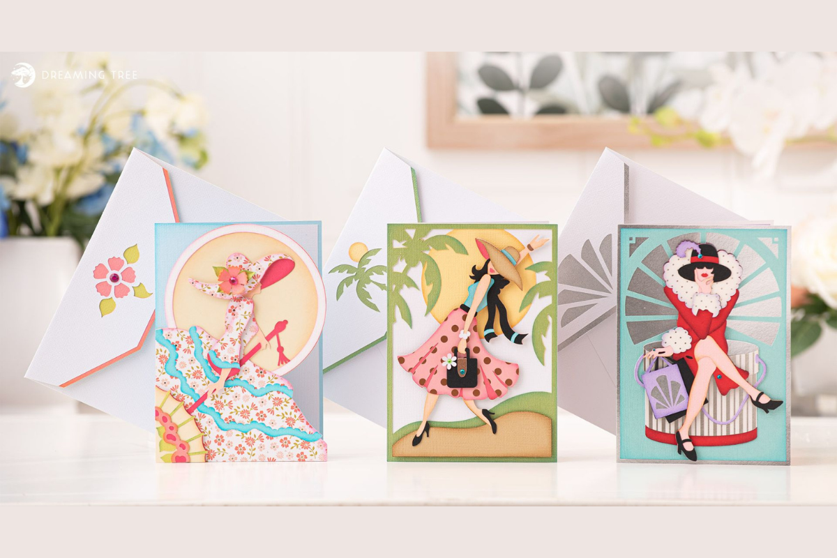Three paper portrait cards of women with hats and flowing hair