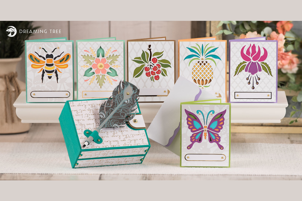 Layered paper cards with bee, butterfly, cherry and pineapple designs plus a hinged box